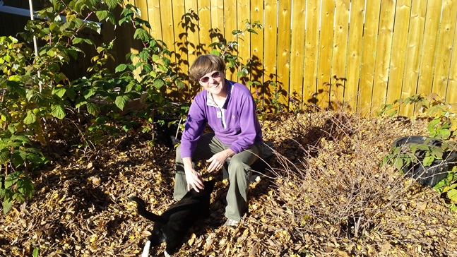 Woman and cat in mulched garden